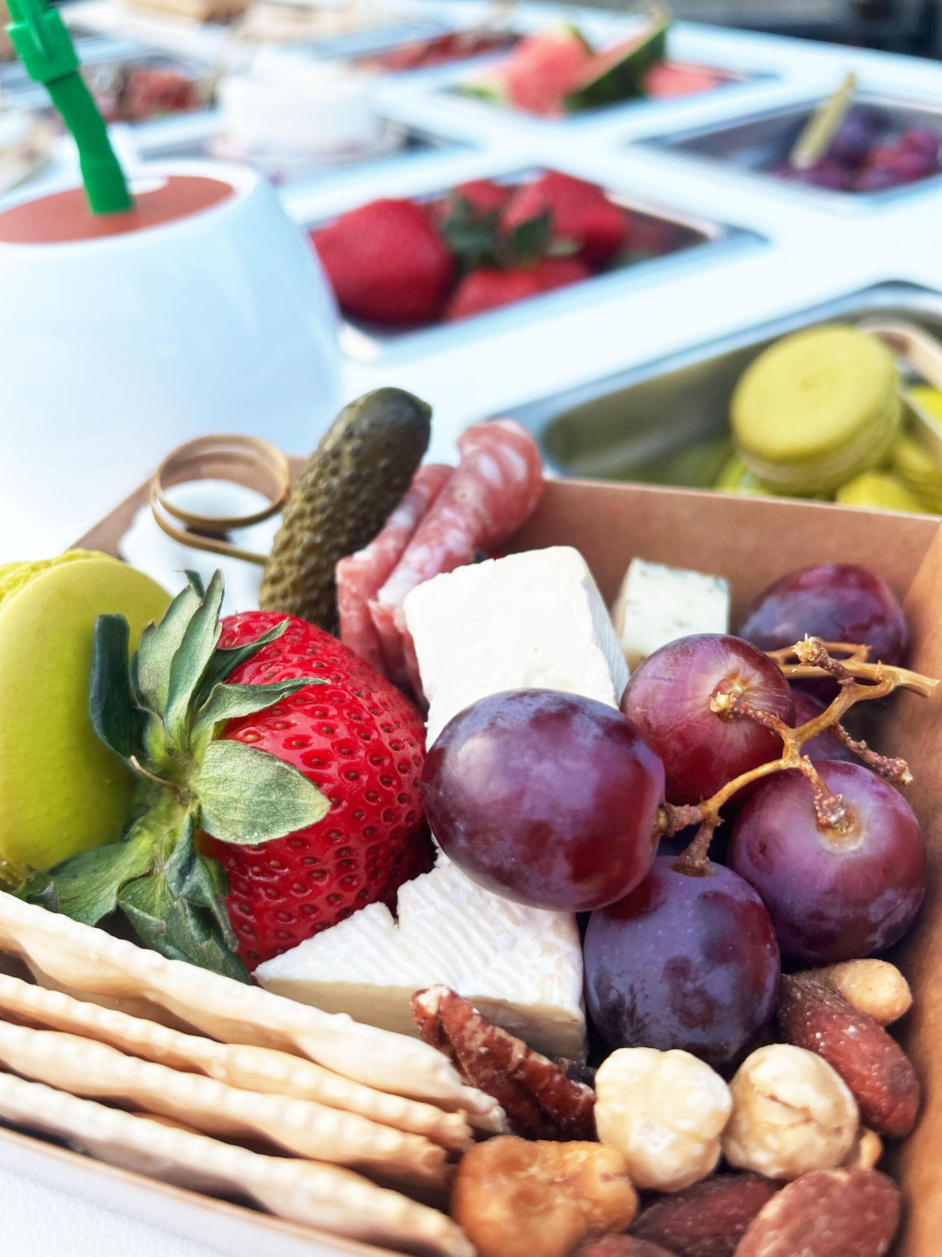 Personal charcuterie box filled with attractively placed crackers, cheeses, fruits and nuts.